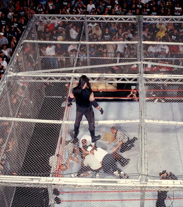 The Undertaker looks on as Mankind is checked on by personel