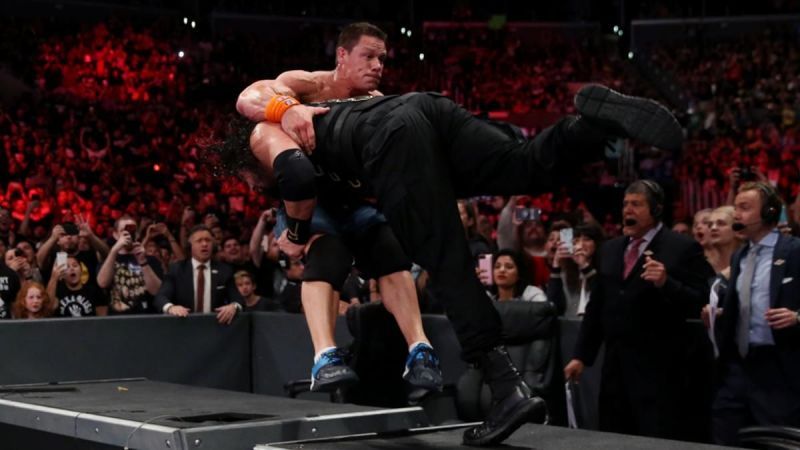 Roman Reigns spears John Cena through the announce table