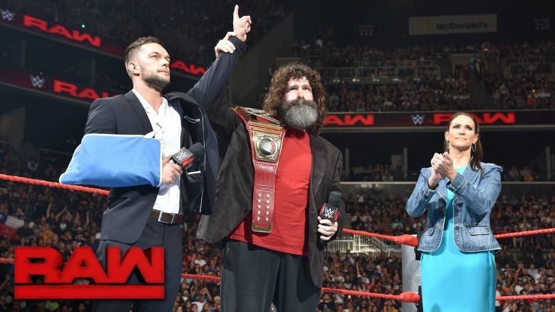 Finn Balor in the ring with Mick Foley and Stepanie McMahon 