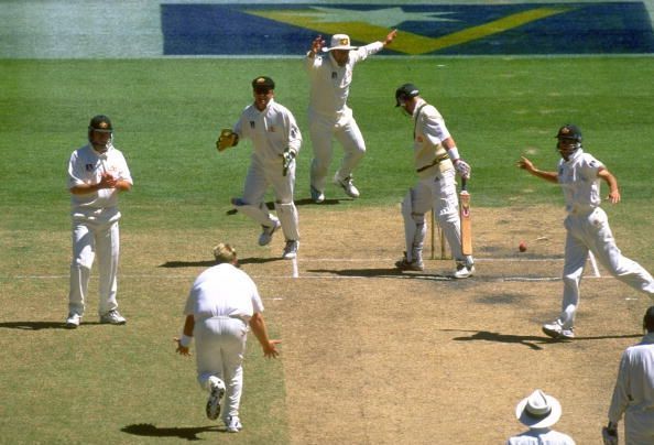 Shane Warne of Australia (second left) bowls Darryl Cullinan of South Africa