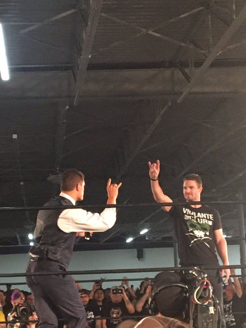 Stephen Amell doing the Too Sweet gesture with Cody Rhodes