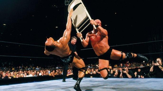 Stone Cold delivers a chair shot to The Rock