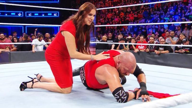Triple H being helped up by Stephanie McMahon