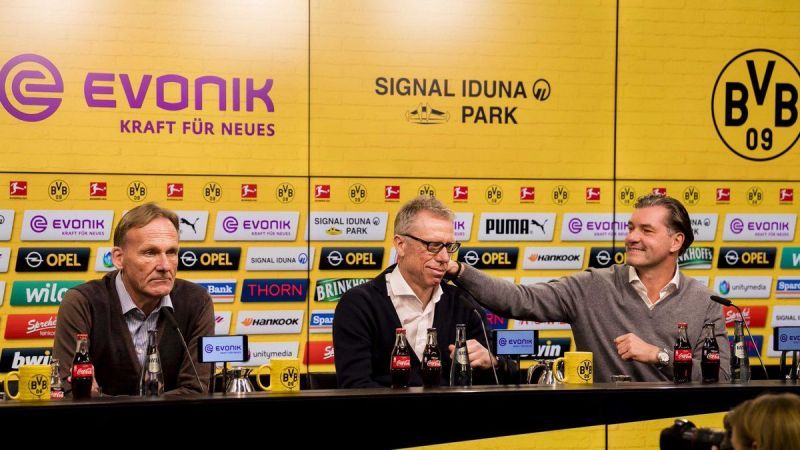 Stöger (middle) during the press conference with BVB bosses Joachim Watzke (left) & Zorc (right)