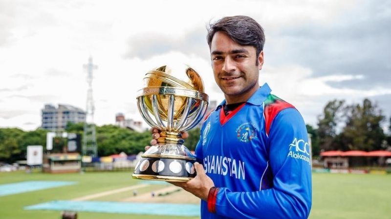 Rashid Khan posing with the ICC World Cup Qualifiers winners&#039; trophy