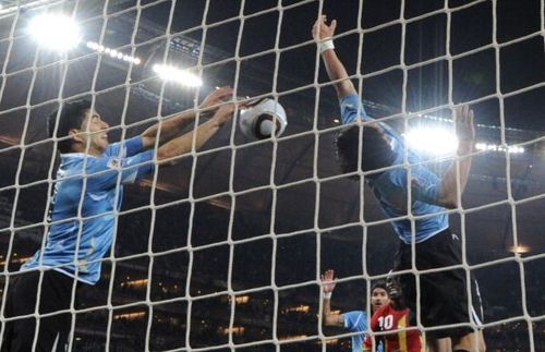 Uruguay's striker Luis Suarez (L) stops