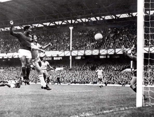 World Cup Finals, 1966. Liverpool, England. 19th July, 1966. Portugal 3 v Brazil 1. Eusebio of Portugal (L) beats Brazil&#039;s Orlando to the ball to head home his side&#039;s second goal past Brazilian goalkeeper Manga during their Group Three match