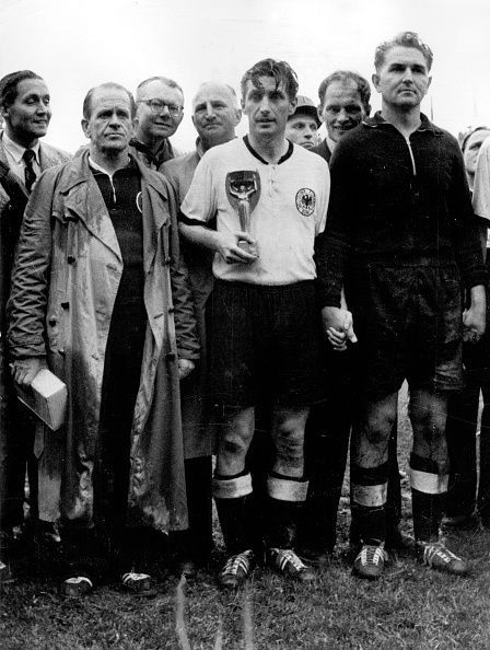 Football 1954 FIFA World Cup, Final in Berne, Switzerland: Germany vs. Hungary 3:2. Player Josef Herberger (left) standing next to Fritz Walter (center) and goalkeeper Anton &#039;Toni&#039; Turek after the presentation ceremony. Team captain Walter is holding