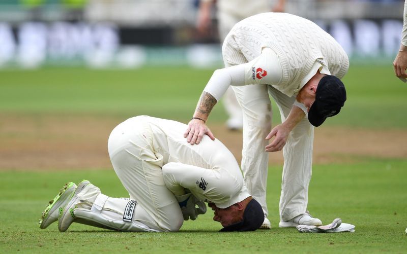 Bairstow kneeling on the ground in pain after being struck on his finger