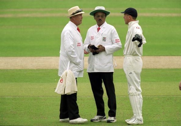 Alec Stewart confers with the umpires during a Test match 