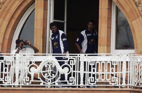 Sri Lankan spin bowler Muttiah Muralitharan watches from the pavilion