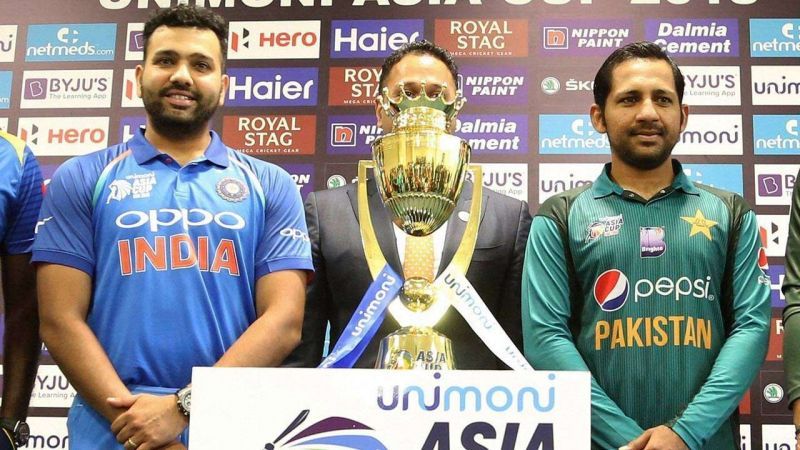 Indian captain Rohit Sharma and Pakistan captain Sarfraz Ahmed pose for a picture with the trophy in middle