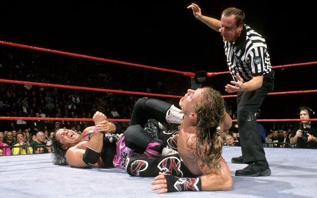 Shawn and Bret stared on as the referee rang the bell