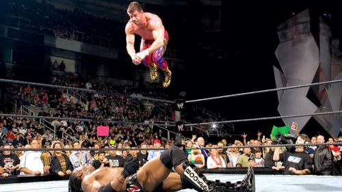 Latino Heat Eddie Guerrero dives off the top rope with his patented Frog Splash on a helpless Booker T.