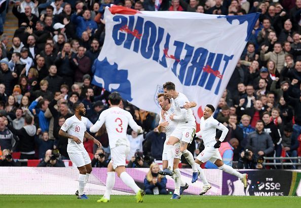 Kane is mobbed after netting a late winner for England, securing their Nations League semi-final spot