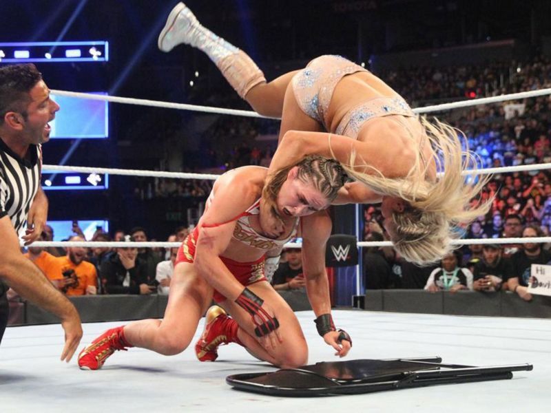 Charlotte Flair batters Ronda Rousey in the post-match of their Survivor Series bout