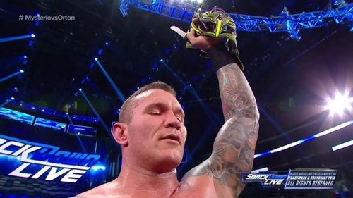 Randy Orton showing off Rey's Mask as a trophy.