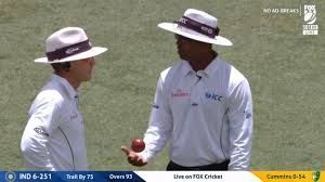 Umpires discussing after referring to the TV umpire with a soft signal