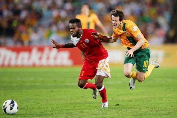 Saad Al-Mukhaini of Oman in red jersey against Australia during the FIFA World Cup Asian Qualifier