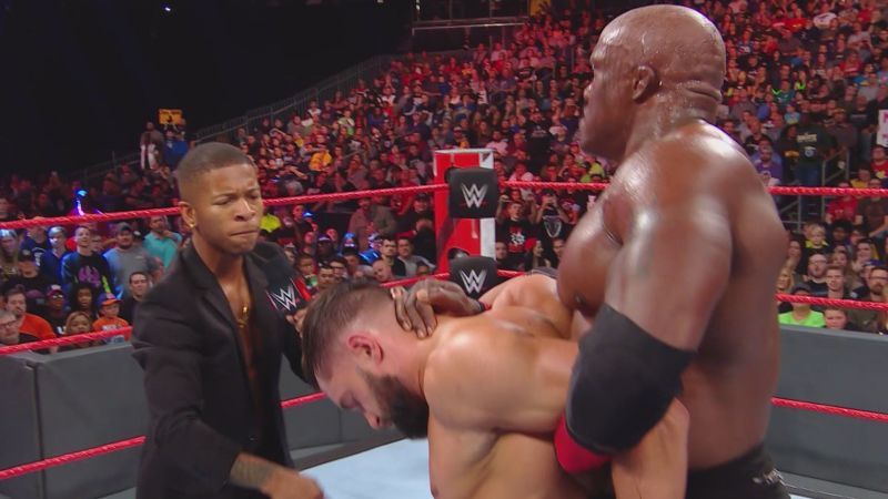 Lio Rush attacking Finn Balor, who&#039;s held by Bobby Lashley