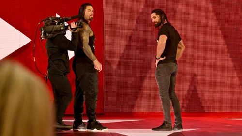 Roman Reigns and Seth Rollins looking at a fallen Dean Ambrose!