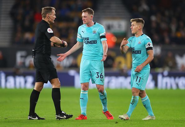 Sean Longstaff and Matt Ritchie argue with the referee over a decision