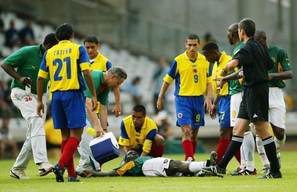 Marc-Vivien Foe of Cameroon is helped by Colombian captain Ivan Cordoba