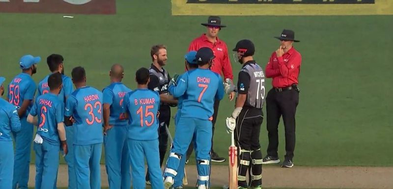 Rohit Sharma and MS Dhoni having a discussion with the two batsmen and the umpires