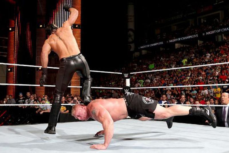 Seth Rollins stomps Brock Lesnar.