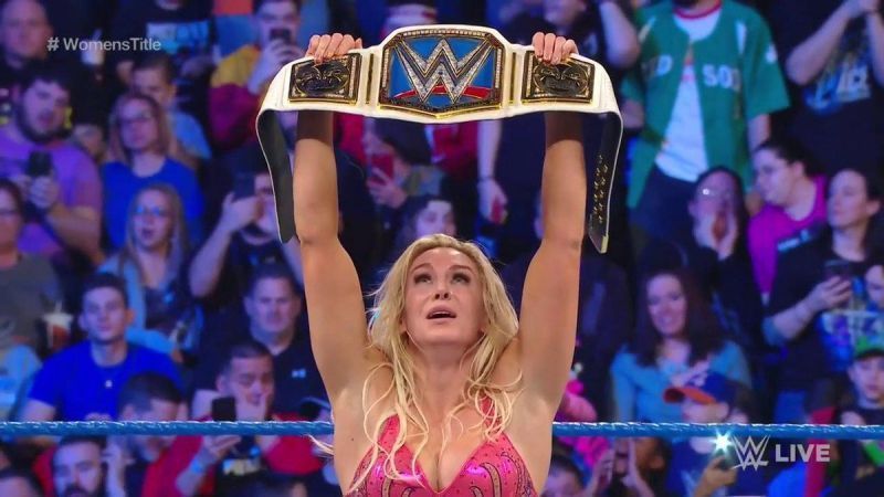 Charlotte Flair hefts the WWE Smackdown Women&#039;s title overhead