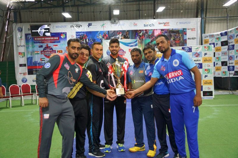 The Captains of Singapore, Singapore A, New Zealand, India, Sri Lanka, UAE and Malaysia pose with the NZ-Asia Cup Trophy (Image Courtesy: Singapore Cricket Association)