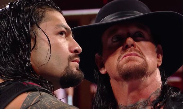 Taker and Reigns looking at the Mania sign