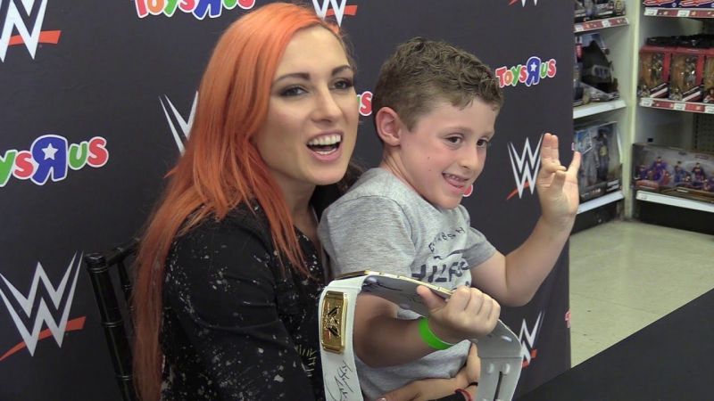 Becky Lynch with a young male fan. Lynch's popularity transcends age, race, and gender.