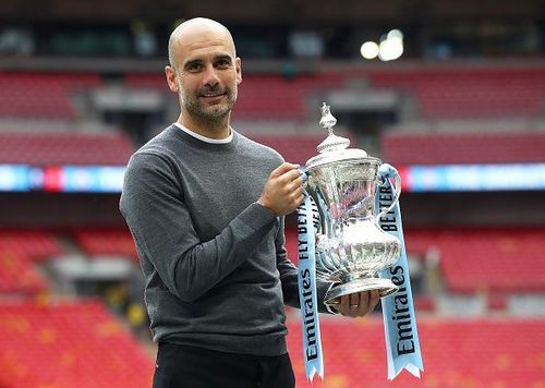 Manchester City's Pep Guardiola holds the FA Cup.