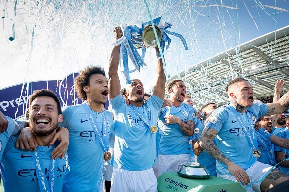 Manchester City players celebrate with the Premier League trophy after finishing the season on 98 points