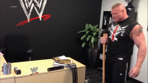 Brock Lesnar holding Triple H's sledgehammer