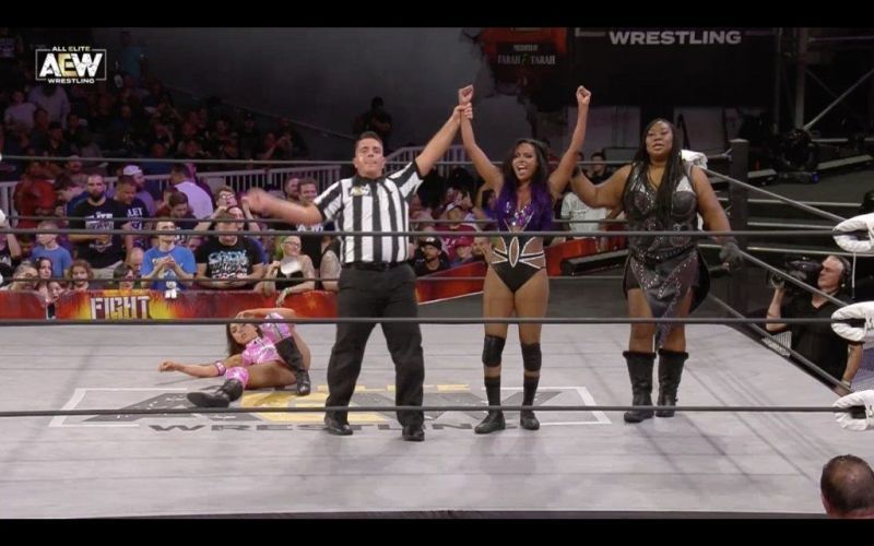 Brandi Rhodes has her hand raised in victory after defeating Allie, with a little help from Awesome Kong.