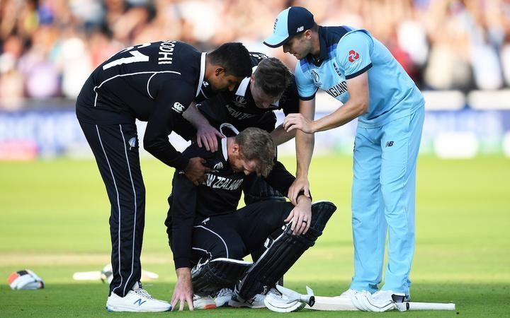 A devastated Guptill is consoled by teammates Neesham and Sodhi