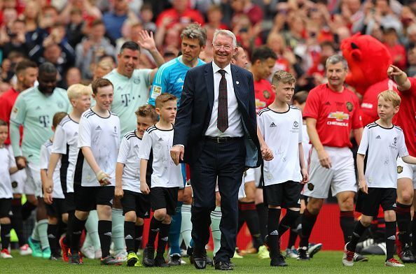 Sir Alex Ferguson with the class of &#039;99 team in the background.