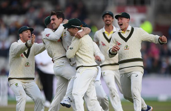 Team-mates swarm around Cummins after Root's dismissal.