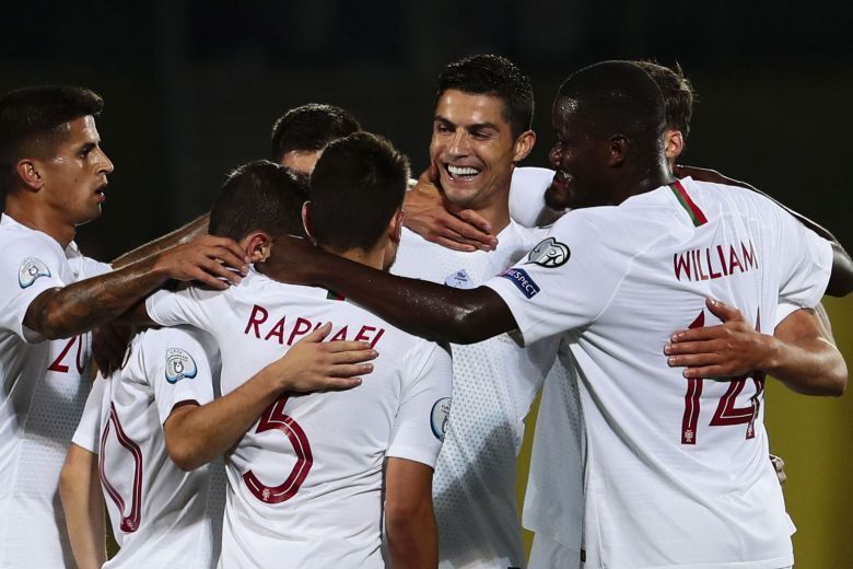 Portugal players rejoice after scoring a goal against Lithuania