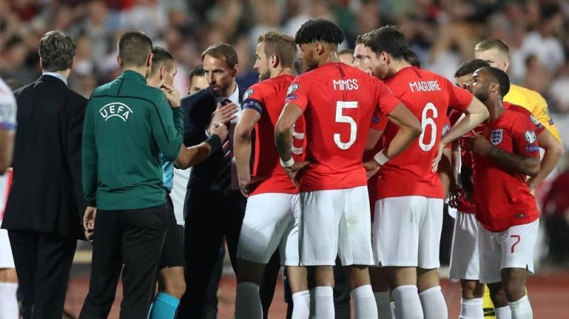 England players crowd around the match officials as racial abuse threatened to see the game abandoned