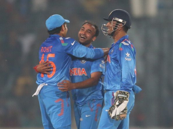 Amit Mishra being congratulated by Rohit Sharma and MS Dhoni.