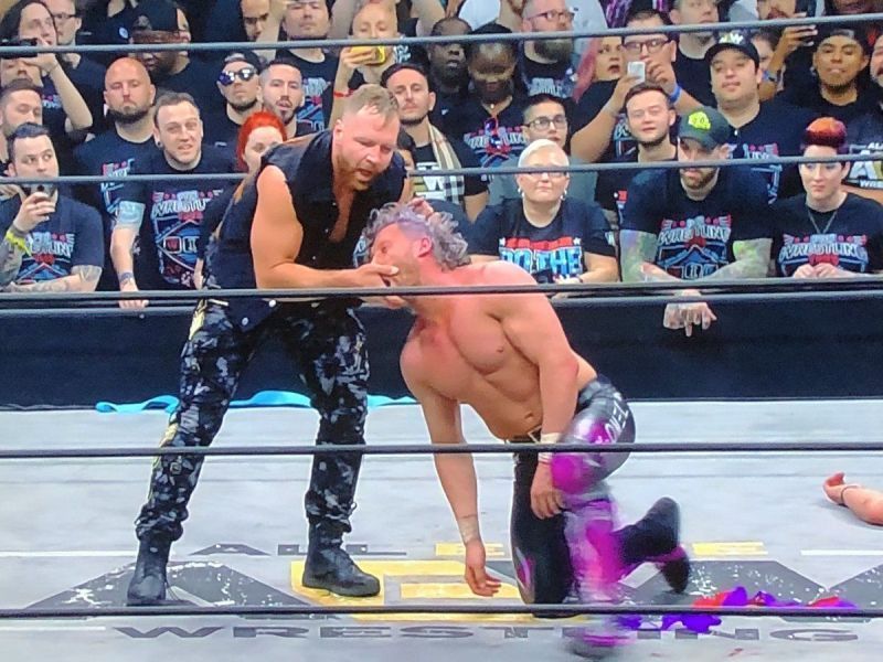 Jon Moxley attacks Kenny Omega.