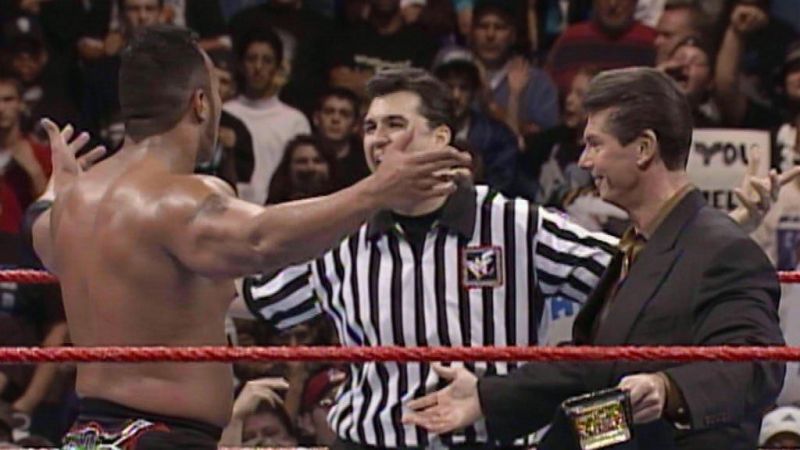 The Rock embraces Shane McMahon and Vince McMahon after winning the WWF World Championship