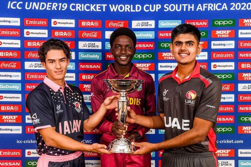 Japan's captain Marcus Thurgate (L) poses with the U-19 World Cup trophy