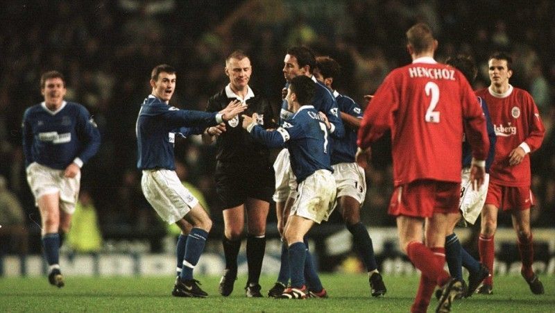 Everton players surround the referee during the Merseyside derby