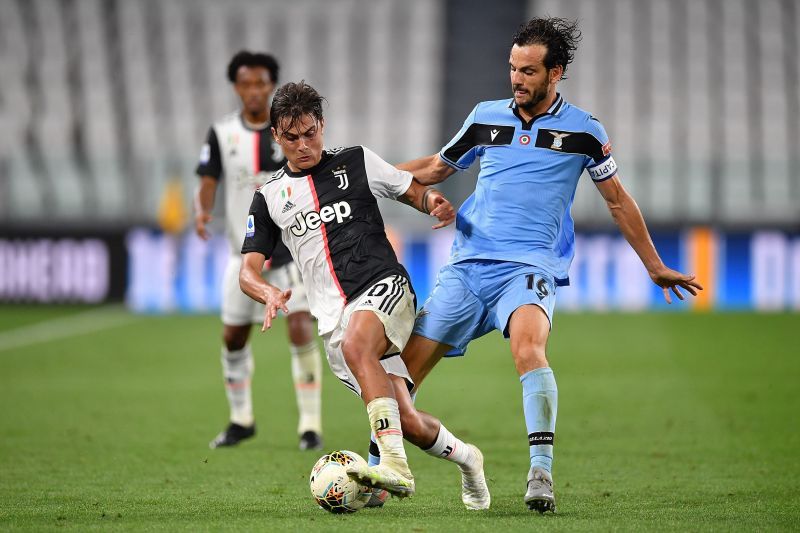 Marco Parolo attempts to tackle Paulo Dybala 