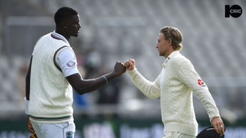 Jason Holder (L) and Joe Root exchange a fist bump during the second Test