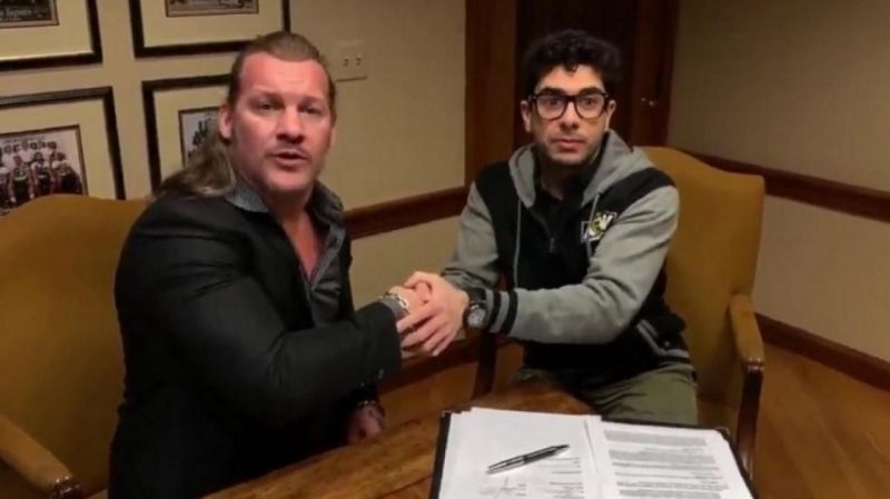 Tony Khan and Chris Jericho signing a contract on AEW
